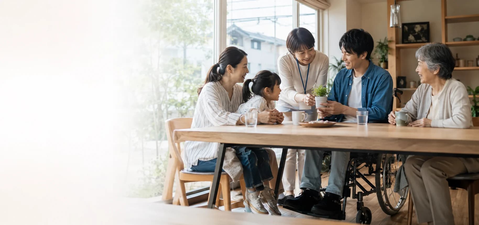 スタッフと三世代の家族が食卓で寄り添う様子
